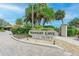Elegant community sign for Midnight Cove Bayside with lush tropical landscaping at 6342 Midnight Pass Rd # 212, Sarasota, FL 34242