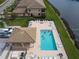 Aerial view of the community pool with chairs, landscaping, and people enjoying a refreshing swim at 6638 Willowshire Way, Bradenton, FL 34212