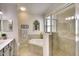 Well-lit bathroom boasting a glass-enclosed shower, soaking tub, and a stylish window for added charm at 6638 Willowshire Way, Bradenton, FL 34212