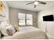 Cozy bedroom with a decorative bed frame, ceiling fan, and a flat screen TV for entertainment at 6638 Willowshire Way, Bradenton, FL 34212