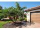 Exterior view of a home with a brick driveway, palm trees, and manicured landscaping at 6638 Willowshire Way, Bradenton, FL 34212