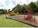 Community playground with swings, slides, and climbing structures surrounded by lush greenery at 6638 Willowshire Way, Bradenton, FL 34212