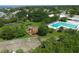 Aerial view of a pool, playground, picnic shelter, and green space surrounded by mature trees and landscaping at 6731 Northampton Pl, Bradenton, FL 34207