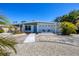 Inviting home with blue door, well-maintained lawn, xeriscaping, and comfortable outdoor seating at 6731 Northampton Pl, Bradenton, FL 34207