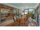Sunroom features a dining table with seating, views into the living room, and lush backyard at 6731 Northampton Pl, Bradenton, FL 34207
