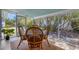 A sunroom features a dining table with seating and views of lush landscaping at 6731 Northampton Pl, Bradenton, FL 34207