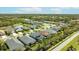 An aerial view displaying the neighborhood and homes with beautiful landscaping and nearby serene lake at 7012 White Willow Ct, Sarasota, FL 34243