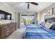Bright bedroom with a ceiling fan and slider doors to an outdoor pool area at 7012 White Willow Ct, Sarasota, FL 34243