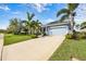 Beautiful home exterior with a well-kept lawn, vibrant landscaping, and a spacious driveway leading to a garage at 7012 White Willow Ct, Sarasota, FL 34243