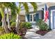 Beautiful entryway showcases landscaped garden with colorful plants, and an American flag displayed at the front of the house at 7012 White Willow Ct, Sarasota, FL 34243