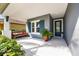 Inviting front porch features a bench with a view, an accent door, and tasteful landscaping for added curb appeal at 7012 White Willow Ct, Sarasota, FL 34243