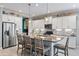 Bright kitchen with a center island featuring pendant lights, stainless appliances, and white cabinets with backsplash at 7012 White Willow Ct, Sarasota, FL 34243