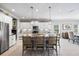 Modern kitchen featuring white cabinets, a backsplash, a large center island with seating, and stainless steel appliances at 7012 White Willow Ct, Sarasota, FL 34243