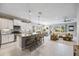 Open-concept kitchen with stainless steel appliances, a large island, pendant lighting, and views into the living area at 7012 White Willow Ct, Sarasota, FL 34243