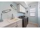 Laundry room featuring a white sink, cabinets, and washer/dryer at 7012 White Willow Ct, Sarasota, FL 34243
