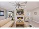 Comfortable living room featuring a stone fireplace, mounted TV, neutral color palette, and tile flooring at 7012 White Willow Ct, Sarasota, FL 34243