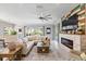 Bright living room with a modern fireplace, large sectional sofa, and oversized ceiling fan at 7012 White Willow Ct, Sarasota, FL 34243