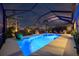 Screened pool with a beautiful night view, stylish seating, and lush landscaping for outdoor relaxation at 7012 White Willow Ct, Sarasota, FL 34243