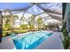 Inviting screened pool with patio furniture, surrounded by manicured landscaping and a sunny atmosphere at 7012 White Willow Ct, Sarasota, FL 34243