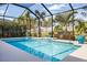 Sparkling pool with a screened enclosure, complemented by vibrant landscaping and ample sunshine at 7012 White Willow Ct, Sarasota, FL 34243