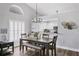 Dining room featuring seating for six, modern lighting, wood floors, and easy access to the kitchen and living area at 7128 Melrose Pl, Bradenton, FL 34203