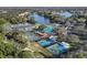 Aerial view of community tennis and pickleball courts surrounded by trees and a lake at 7133 Victoria Cir, University Park, FL 34201