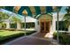 Inviting clubhouse entrance with manicured landscaping and a striking teal awning at 7133 Victoria Cir, University Park, FL 34201