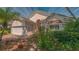 Charming home featuring a well-manicured lawn, lush landscaping, and beautiful curb appeal under a bright, sunny sky at 7133 Victoria Cir, University Park, FL 34201