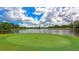 Beautiful golf course featuring a pond with the green in the foreground under a cloudy sky at 7133 Victoria Cir, University Park, FL 34201
