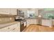 Modern kitchen with stainless steel appliances, granite countertops, and white cabinets for a clean and elegant look at 7133 Victoria Cir, University Park, FL 34201