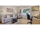 Bright living room features a comfortable couch, desk, and large window with natural light at 7133 Victoria Cir, University Park, FL 34201