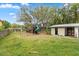 Large backyard with mature trees, grassy area, and playground offering ample outdoor space at 730 Rellim Ln, Sarasota, FL 34232