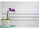 Bathroom detail with orchid, glass shelf, and subway tile with accent stripe at 730 Rellim Ln, Sarasota, FL 34232