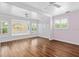 Bright bedroom featuring hardwood floors, a tray ceiling, large windows, and a window seat at 730 Rellim Ln, Sarasota, FL 34232