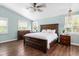 Bright bedroom boasts beautiful wood floors, vaulted ceilings, and a large bed, with natural light streaming through the windows at 730 Rellim Ln, Sarasota, FL 34232