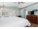 Well-lit bedroom features French doors, a ceiling fan, and ample storage in the dresser at 730 Rellim Ln, Sarasota, FL 34232