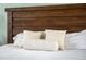 Close up of made bed featuring a decorative wooden headboard and bright white linens at 730 Rellim Ln, Sarasota, FL 34232