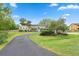 Charming two-story home with a well-maintained lawn, mature trees, and a driveway at 730 Rellim Ln, Sarasota, FL 34232