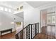 Open foyer featuring a custom metal staircase railing, hardwood floors, and natural light at 730 Rellim Ln, Sarasota, FL 34232