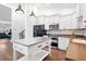 Bright kitchen features white cabinets, central island, stainless appliances, and decorative backsplash at 730 Rellim Ln, Sarasota, FL 34232