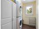 Convenient laundry room with stacked washer and dryer and storage cabinets for organization at 730 Rellim Ln, Sarasota, FL 34232