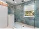 Modern bathroom features a glass walk-in shower with decorative marble tiles and a window at 730 Rellim Ln, Sarasota, FL 34232