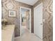 Stylish bathroom featuring damask wallpaper, a vanity with a sink, and an open door to another bathroom at 7300 Wax Myrtle Way, Sarasota, FL 34241