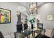 Open dining room showcases a glass-top table, contemporary chandelier, and arched entryway to the living areas at 7300 Wax Myrtle Way, Sarasota, FL 34241