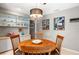 Contemporary dining area with decorative lighting, custom built-in cabinetry and views of unique artwork at 7300 Wax Myrtle Way, Sarasota, FL 34241