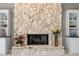 Stone fireplace flanked by built-in cabinets offering open shelving for decor and collectibles at 7300 Wax Myrtle Way, Sarasota, FL 34241
