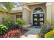Elegant front entrance with beautiful landscaping and a black double door with glass inserts at 7300 Wax Myrtle Way, Sarasota, FL 34241