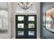 Elegant front doors with glass panes and a chandelier, creating a grand and welcoming entrance at 7300 Wax Myrtle Way, Sarasota, FL 34241