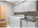 Well-equipped laundry room with modern washer, dryer, and ample storage cabinets at 7300 Wax Myrtle Way, Sarasota, FL 34241