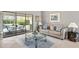 Living room with patio doors leading to a screened pool area, creating a seamless indoor-outdoor living experience at 7300 Wax Myrtle Way, Sarasota, FL 34241